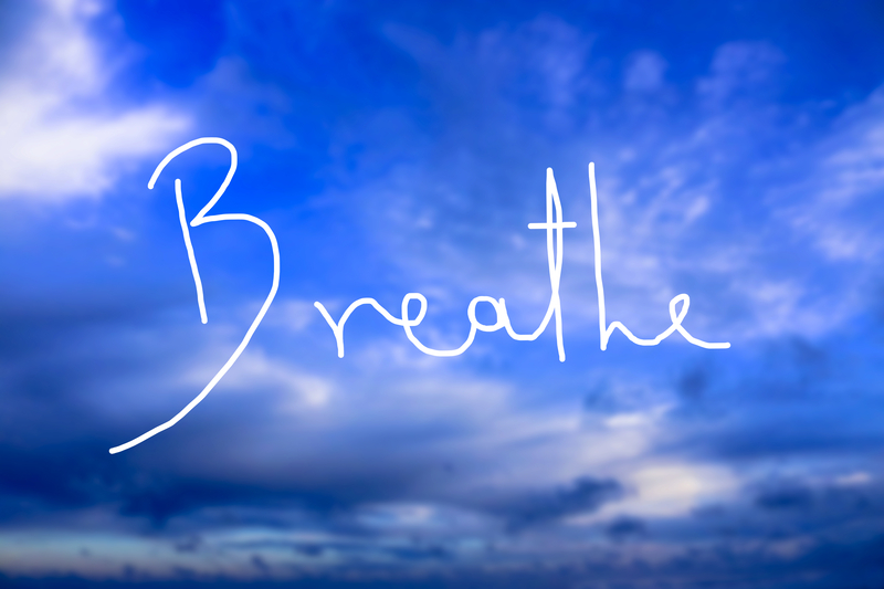 Breathe Handwritten logo in the sky. A handwritten logo as a reminder to breathe consciously and use the breath as a mean for healing and relaxation.